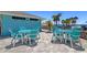 Charming patio area with bright blue outdoor tables and chairs, perfect for gatherings by the beach at 4812 Jasper Dr Dr # 101, New Port Richey, FL 34652