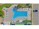 Aerial view of a community pool featuring sun loungers, tables, and lush landscaping at 4812 Jasper Dr Dr # 101, New Port Richey, FL 34652