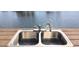 A stainless steel sink with a faucet sits on a wooden deck with water in the background at 4812 Jasper Dr Dr # 101, New Port Richey, FL 34652