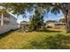 Lush backyard with mature trees, green lawn, and partial view of the house at 4837 97Th N Way, St Petersburg, FL 33708