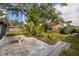 Backyard featuring a stone patio, lush landscaping, and mature trees at 4837 97Th N Way, St Petersburg, FL 33708