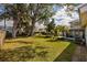 Spacious backyard with mature trees, lush lawn, and a screened-in porch at 4837 97Th N Way, St Petersburg, FL 33708