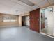 Spacious basement featuring retro wood-paneled walls, brick accents, and concrete floors at 4837 97Th N Way, St Petersburg, FL 33708