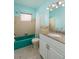 Retro bathroom features teal accents, a granite countertop, vanity, and shower-tub combo at 4837 97Th N Way, St Petersburg, FL 33708