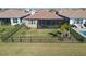 Aerial view of fenced backyard, pool, screened patio, and beautiful lake at 4911 Sienna Isles Ave, Wimauma, FL 33598