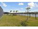 Spacious backyard with lush lawn, lake view, and black metal fence at 4911 Sienna Isles Ave, Wimauma, FL 33598