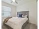 Bright bedroom showcasing a bed with gray headboard, plush pillows and comfortable blanket at 4911 Sienna Isles Ave, Wimauma, FL 33598