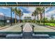 Outdoor bocce ball court with covered seating, lush tropical landscaping, and a paved walkway at 4911 Sienna Isles Ave, Wimauma, FL 33598