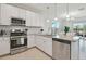 Well-lit kitchen with stainless steel appliances, white cabinets, and granite countertops at 4911 Sienna Isles Ave, Wimauma, FL 33598