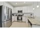 Modern kitchen with stainless steel appliances, white cabinetry, and granite countertops at 4911 Sienna Isles Ave, Wimauma, FL 33598