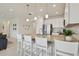 Bright, modern kitchen featuring a granite countertop island with pendant lighting and white cabinetry at 4911 Sienna Isles Ave, Wimauma, FL 33598