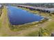 Aerial view of the beautiful community pond with mature landscaping and waterfront homes at 4911 Sienna Isles Ave, Wimauma, FL 33598