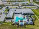 Aerial view of a luxurious community center with a pool, splash pad, lounge seating, and palm trees at 4911 Sienna Isles Ave, Wimauma, FL 33598