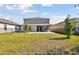 Spacious fenced backyard featuring a stone patio, grass, and a view of the home at 5134 Ballantrae Blvd, Land O Lakes, FL 34638