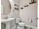 Charming half bathroom with a pedestal sink, decorative shelves, and stylish decor at 5134 Ballantrae Blvd, Land O Lakes, FL 34638