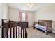 Cozy bedroom featuring two cribs, dresser, and a large window at 5134 Ballantrae Blvd, Land O Lakes, FL 34638