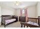 Charming Bedroom with two cribs, dresser, soft carpet, and a window adorned with pink curtains at 5134 Ballantrae Blvd, Land O Lakes, FL 34638