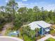 Modern blue clubhouse with a metal roof surrounded by lush trees and includes a nearby playground and walking path at 5134 Ballantrae Blvd, Land O Lakes, FL 34638