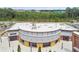 Aerial shot of a distinctive commercial building with a rounded facade, clean lines and abundant parking in a green landscape at 5134 Ballantrae Blvd, Land O Lakes, FL 34638