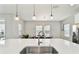 Kitchen island featuring a stainless steel sink, quartz countertop, and modern pendant lighting at 5134 Ballantrae Blvd, Land O Lakes, FL 34638