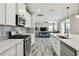 Open kitchen featuring white cabinets, stainless steel appliances, and views into the living room at 5134 Ballantrae Blvd, Land O Lakes, FL 34638