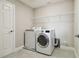 Convenient laundry room featuring washer, dryer, and shelving at 5134 Ballantrae Blvd, Land O Lakes, FL 34638