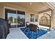 View of the covered patio with outdoor seating, egg chair, and sliding glass door to the home at 5134 Ballantrae Blvd, Land O Lakes, FL 34638