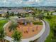 Aerial shot of a community playground nestled among trees, featuring swings, slides, and a circular pathway for recreation at 5134 Ballantrae Blvd, Land O Lakes, FL 34638