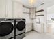 Laundry room with modern washer and dryer, cabinets, sink, and open shelves at 531 Danube Ave, Tampa, FL 33606