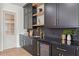 Elegant wet bar featuring dark cabinetry, gold accents, and open shelving for a luxurious entertaining space at 531 Danube Ave, Tampa, FL 33606