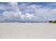 Expansive beach view with white sand, blue skies, and recreational water activities at 5396 Gulf Blvd # 110, St Pete Beach, FL 33706