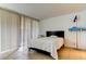 Bright bedroom with large windows, a white bed, and decor at 5396 Gulf Blvd # 110, St Pete Beach, FL 33706