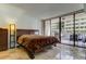 Bedroom features a king-sized bed, tiled floors, and sliding glass doors to a balcony with seating at 5396 Gulf Blvd # 110, St Pete Beach, FL 33706