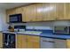 Cozy kitchen with wooden cabinets, an electric stove, a white refrigerator, and blue countertops at 5396 Gulf Blvd # 110, St Pete Beach, FL 33706