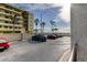 Well-maintained parking lot in front of a beachside condo building with palm trees at 5396 Gulf Blvd # 110, St Pete Beach, FL 33706