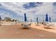 Pool deck with tables, chairs, umbrellas and ocean views on sunny day at 5396 Gulf Blvd # 110, St Pete Beach, FL 33706