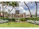 Entrance to Seamark Private Residence with lush landscaping, palm trees, and the building in the background at 5396 Gulf Blvd # 110, St Pete Beach, FL 33706