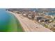 Wide aerial view of a city's coastline featuring residential and commercial buildings, beaches and an ocean inlet at 5396 Gulf Blvd # 904, St Pete Beach, FL 33706