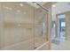 Modern bathroom featuring a glass-enclosed shower, neutral tile, and contemporary fixtures at 5396 Gulf Blvd # 904, St Pete Beach, FL 33706