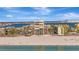 Beautiful exterior view of a beachfront building on a sunny day with cars and pedestrians in the foreground at 5396 Gulf Blvd # 904, St Pete Beach, FL 33706