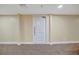 A hallway leading to a unit door, showcasing neutral paint, and carpeted floors at 5396 Gulf Blvd # 904, St Pete Beach, FL 33706