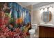 Bright bathroom featuring black and white tile floors, a modern vanity, and a fun, colorful shower curtain at 5518 11Th St, Zephyrhills, FL 33542