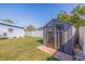 Backyard featuring a shed, well-manicured lawn and partial view of the house in a fenced yard at 5970 66Th N Ter, Pinellas Park, FL 33781