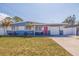 Charming single-story home featuring a red door, well-manicured lawn and two palm trees at 5970 66Th N Ter, Pinellas Park, FL 33781