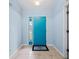 Bright foyer featuring a vibrant blue door and neutral tile flooring at 6131 Tedder St, Port Charlotte, FL 33981