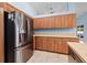 Kitchen with stainless steel refrigerator and wooden cabinets at 6131 Tedder St, Port Charlotte, FL 33981