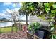 Landscaped backyard with lake views featuring trees and potted plants at 6531 Clair Shore Dr, Apollo Beach, FL 33572