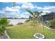 Lush backyard with lake view with tropical trees surrounding the home at 6531 Clair Shore Dr, Apollo Beach, FL 33572