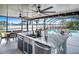 Outdoor kitchen island with double sink overlooking the swimming pool and lake at 6531 Clair Shore Dr, Apollo Beach, FL 33572