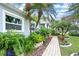 A lush garden pathway with plants, flowers, and stone accents, surrounded by palm trees and greenery at 6531 Clair Shore Dr, Apollo Beach, FL 33572